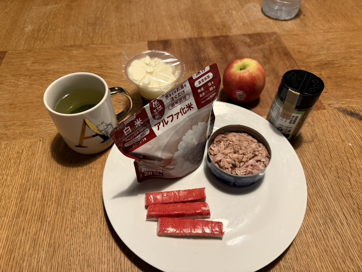 皿にのせたアルファ米・カニカマ・りんごと緑茶